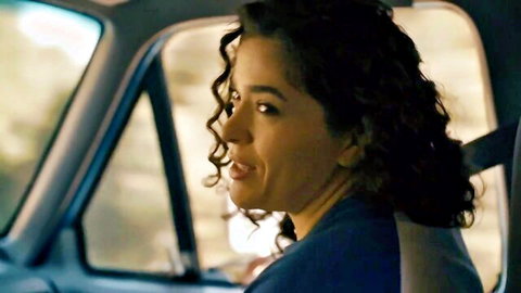 Curly-haired Latina woman in blue top in car from Dorcel Alive HD clip