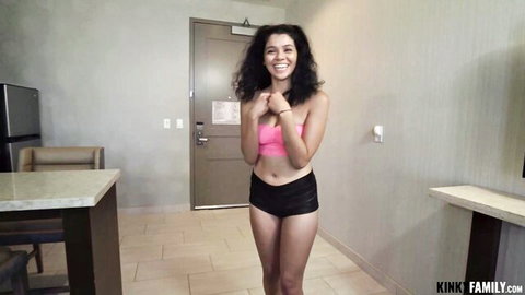 Harley Haze smiling in pink crop top and black shorts, teasing pose