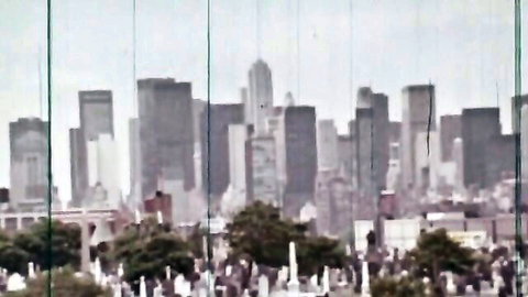 Retro cemetery overlook of NYC skyline in vintage anal porn movie