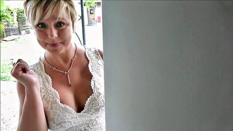 Brianna Beach smiling in low-cut white lace top, showing deep cleavage