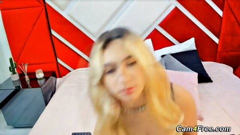 Blonde babe with big tits in black lace top teasing on webcam bed