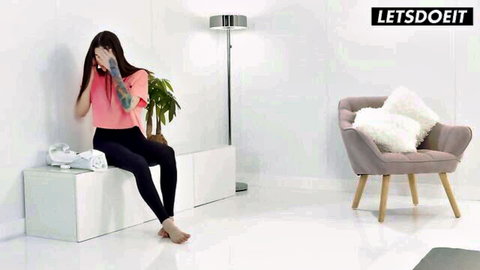 Shy babe in tight pink top and black leggings sits barefoot spreading legs teasingly