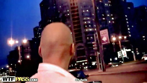 Bald man in pink shirt overlooking urban night skyline, wild pickup vibe