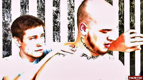 Tattooed bald bearded man and friend in close embrace, hinting at orgy action