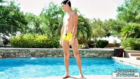 Skinny young brunette in tight yellow leopard speedo shows huge cock bulge by pool