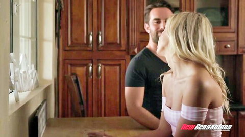 Blonde Khloe Kapri in pink top smiles back at Logan Pierce during intimate kitchen moment