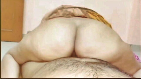 Close-up of thick Indian woman's bare fat ass above husband's hairy belly in homemade bedroom sex.
