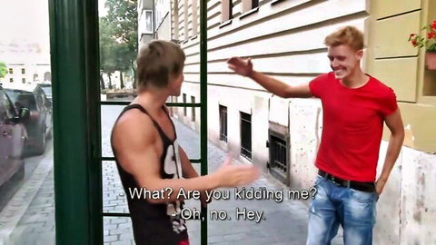 Two athletic young blondes gesturing excitedly on street in tank top and red shirt
