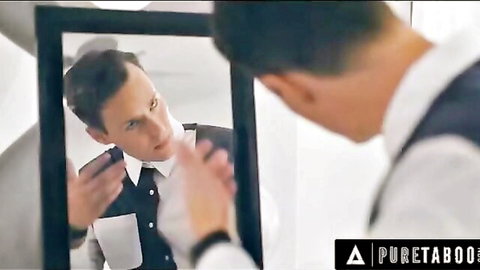 Suited man smirks intensely at his mirror reflection adjusting collar seductively