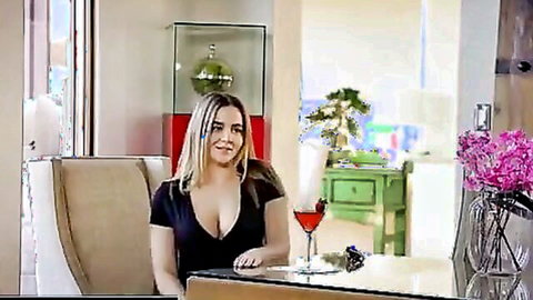 Busty blonde babe in low-cut black dress teasing huge tits with martini glass