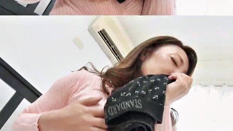 Mature Japanese woman in pink sweater sniffing black panties teasingly