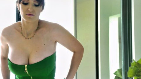 Lexi Luna in low-cut green dress showcasing her massive cleavage and big tits