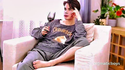 Sexy guy in Skamwreck sweater lounging barefoot spreading legs holding wine glass teasing