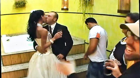 Sexy black bride in beaded wedding dress passionately kissing suited groom by hot tub