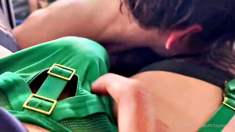Muscular stud gropes brunette in shiny green buckled harness fetish outfit