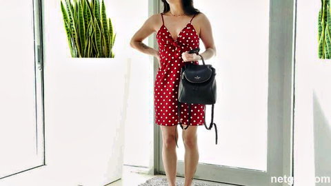 Sexy Asian woman in red polka-dot dress poses teasingly, ready to get naughty