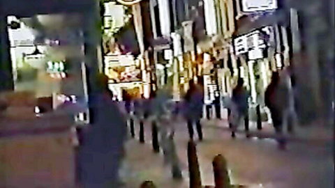 Blurry nighttime street scene with pedestrians, busty European babe context