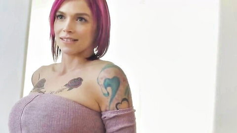 Anna Bell Peaks in tight purple off-shoulder top, pink hair, tattoos, seductive smile