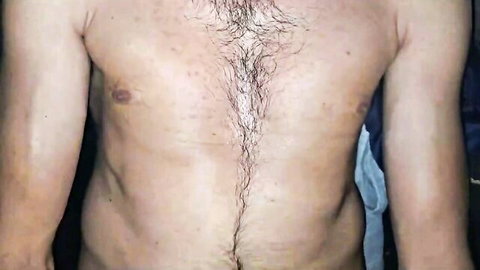 Hairy chested muscular man exposing shirtless torso with thick happy trail