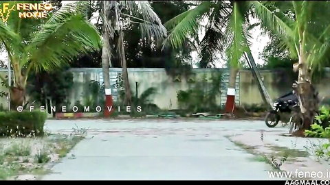 Outdoor Indian courtyard with palm trees compound wall and parked scooter