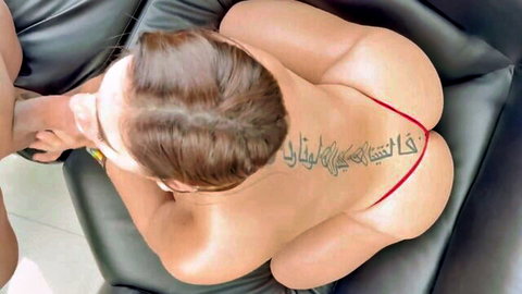 Top-down view of nude woman's exposed pussy and asshole with red thong pulled aside on leather couch