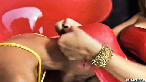 TS domme with bangles yanks yellow rope bondage on sub's neck over red chair