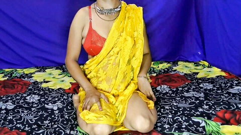 Sexy Indian woman in sheer yellow saree and red bra showing big tits cleavage and thighs on bed