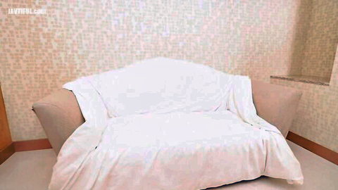 Empty white-sheet-covered beige loveseat in tiled room awaiting kinky foot worship