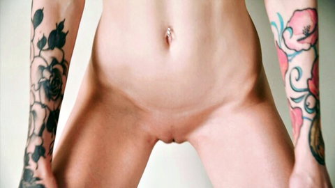 Inga's tattooed nude body with navel piercing, spreading legs in solo masturbation mirror view