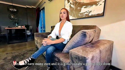 Busty Latina babe with deep cleavage in unbuttoned white blouse sits on couch for interview