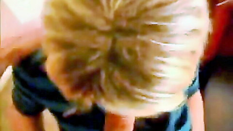 Top-down POV of blonde with long hair and dark shirt collar in teasing pose
