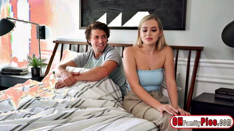 Sexy blonde babe with big tits in tube top sitting on bed with fit guy