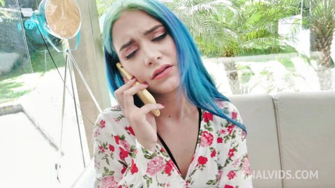 Turquoise haired beauty in low-cut floral dress teasing cleavage while talking on phone