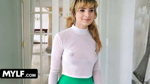Alaina Taylor in sheer white top and green skirt, smiling seductively