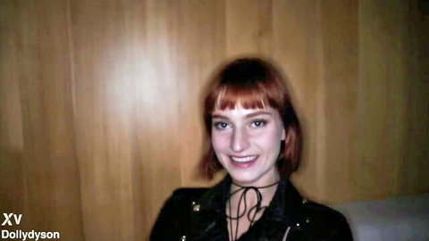 Smiling redhead babe with bob haircut in sexy black leather jacket and choker