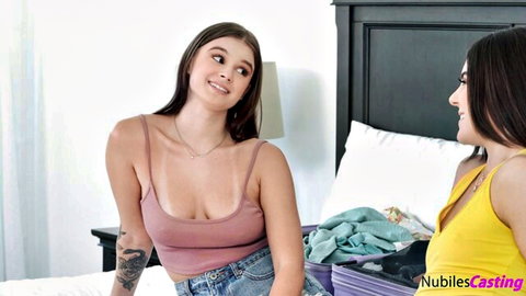 Megan Marx and Sky Wonderland in pink tank top and yellow top on bed for Nubiles Casting