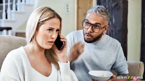 Blonde busty MILF surprised on phone as man gestures excitedly nearby