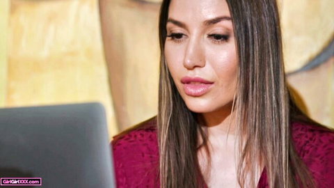 Desiree Dulce seductively poses in red lace top, gazing at laptop