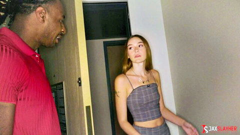 Black stud in red shirt eyes busty blonde in skimpy gray crop top at doorway