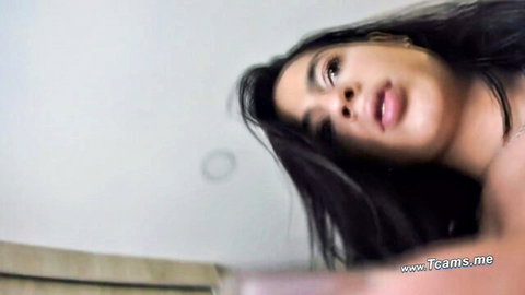 Seductive Latina with long dark hair looking up passionately in cam show