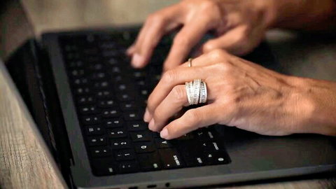 Dana Vespoli's manicured hands with diamond ring typing erotic missive on laptop