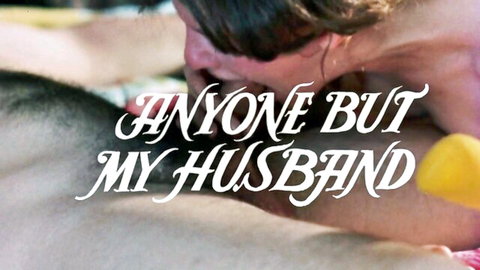Cheating wife embraces lover passionately in retro adult film scene