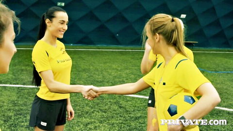 Blonde and brunette soccer babes in tight yellow jerseys shaking hands on field