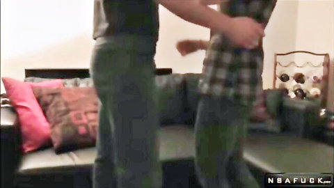 Plaid shirt guy gropes woman's round ass in tight green pants from behind by gray sofa
