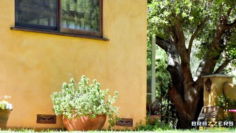Abella Danger in sunny outdoor Brazzers scene with yellow house and plants