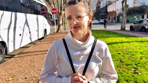 Kate Rich smiling in white turtleneck sweater and suspenders outdoors