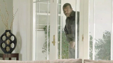Intense ebony man peeking through glass doors in rough straight scene