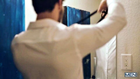 Handsome man in white shirt adjusting black tie in bathroom mirror reflection