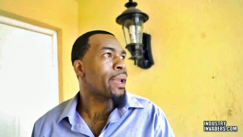 Shocked black man with goatee in open blue shirt looking surprised