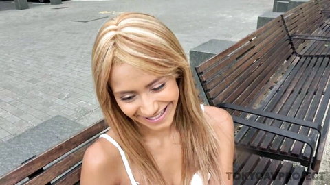 Veronica Leal smiling teasingly in white top, petite curvy blonde